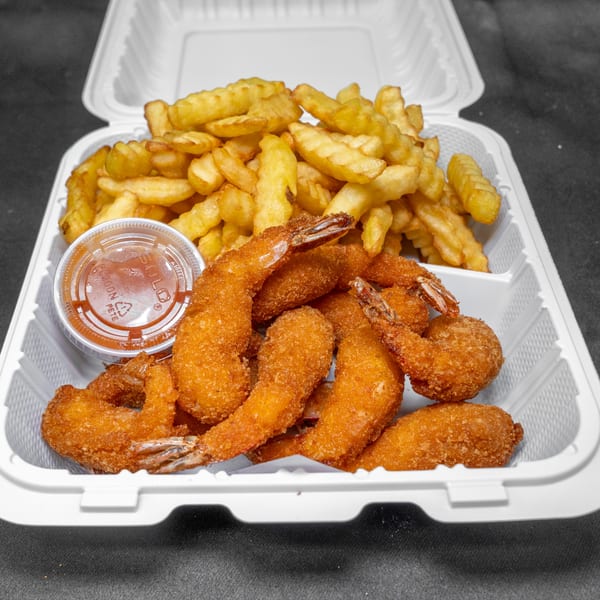 Golden fried shrimp and crinkle fries with dipping sauce in a white to-go box.